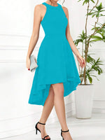 Woman wearing a turquoise dress with a white background and plant