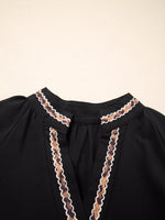 Black garment with lace detailing on a beige background