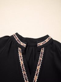 Black garment with lace detailing on a beige background