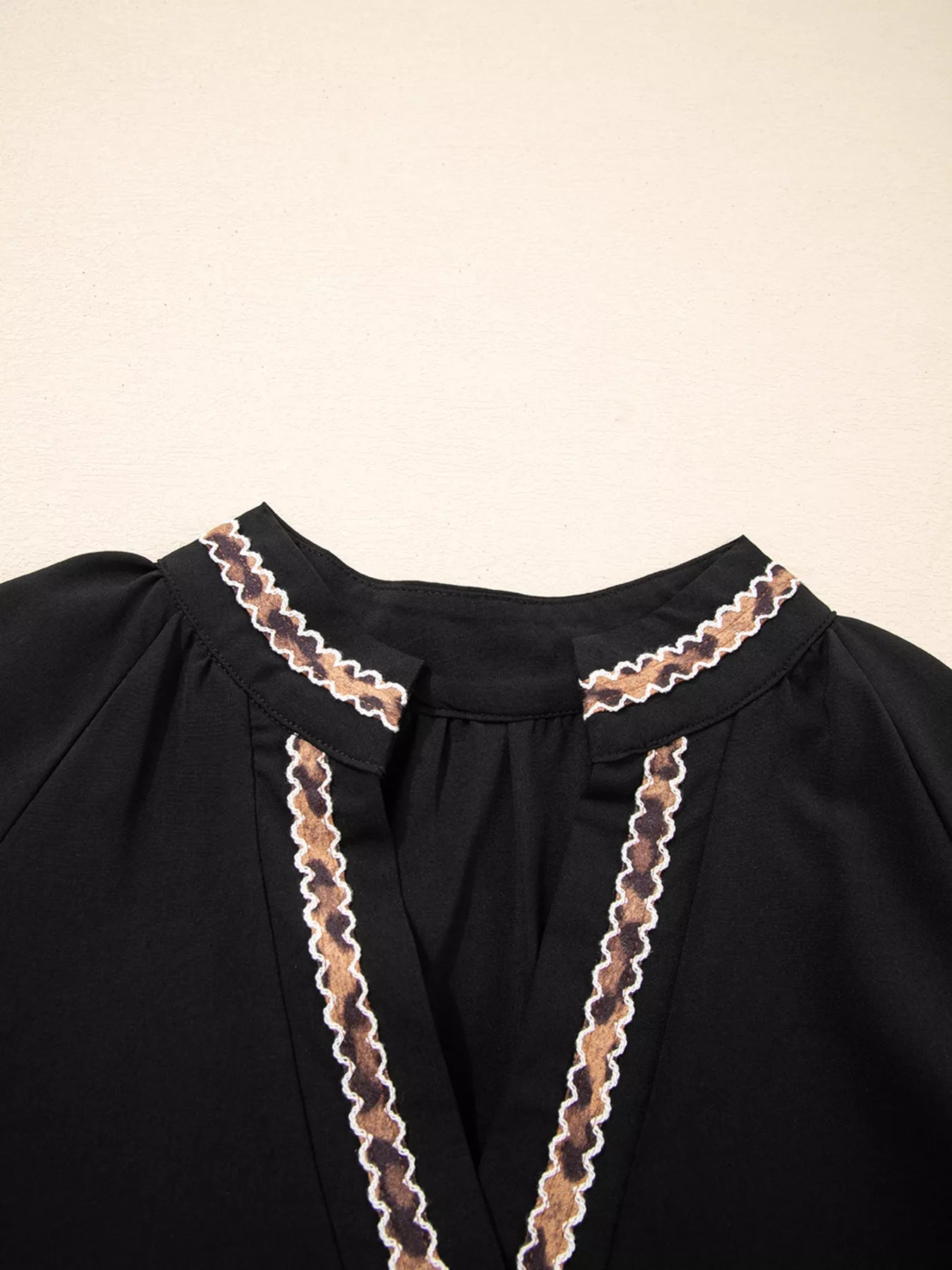 Black garment with lace detailing on a beige background