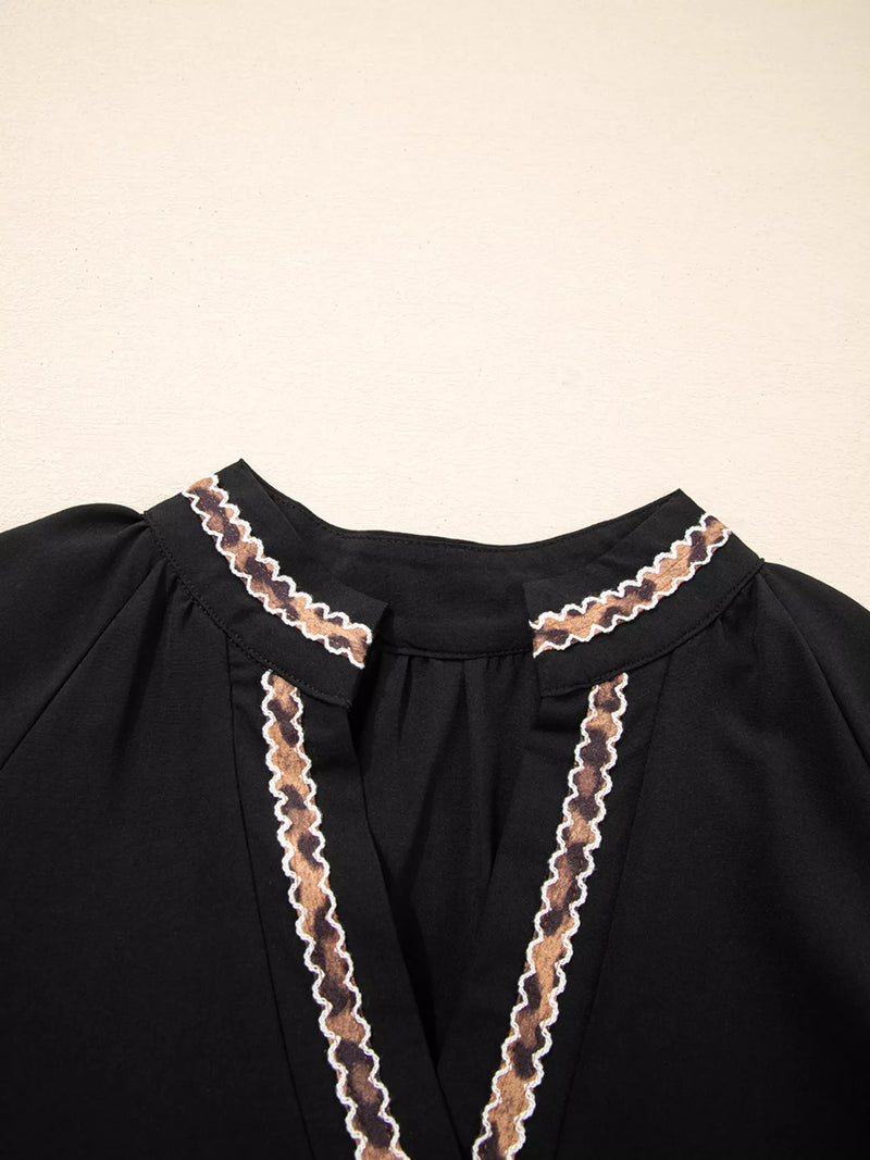 Black garment with lace detailing on a beige background