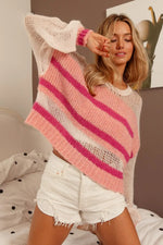 Woman wearing a pink and white striped sweater with a abstract painting in the background