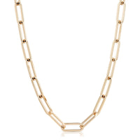 A gold-colored large elongated link chain necklace laid out on a plain background.