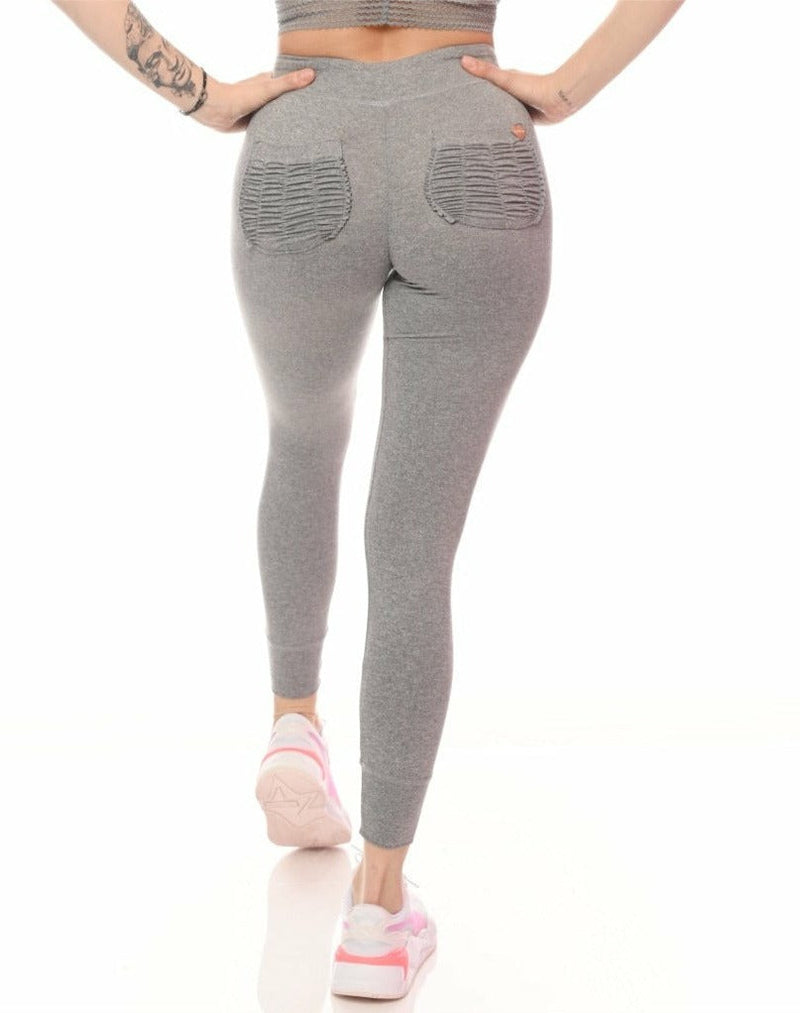 Person wearing gray leggings with pockets on a white background