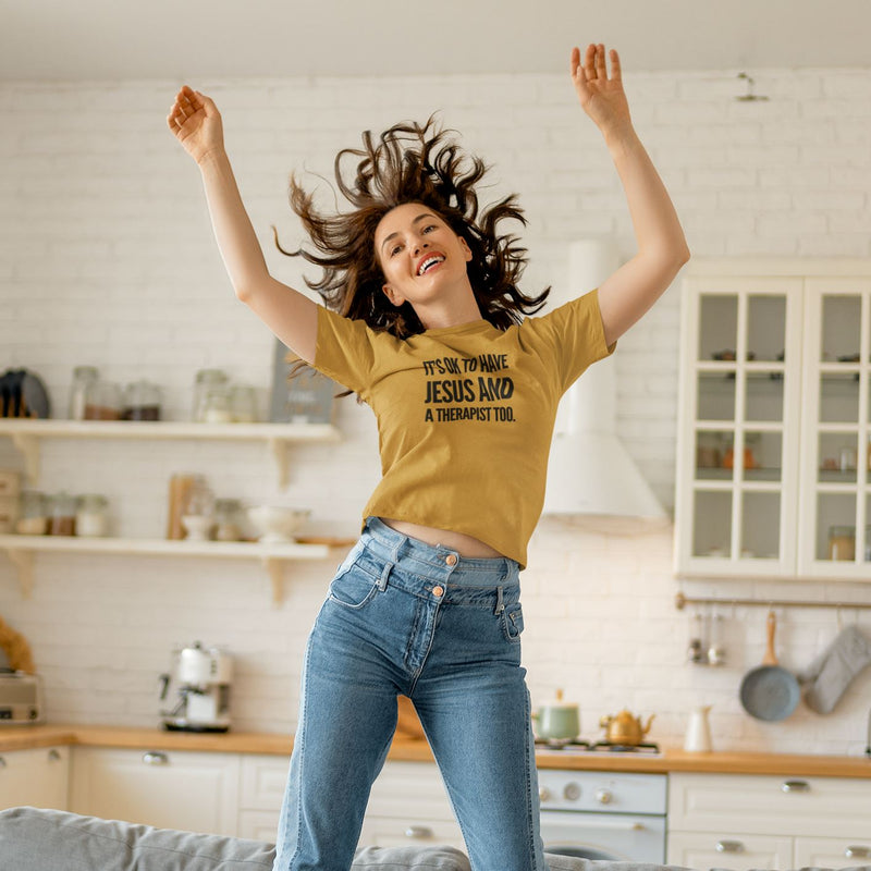 Woman in a yellow t-shirt with text in a kitchen