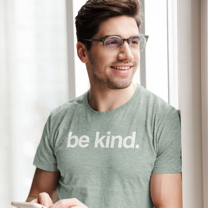 Man wearing a 'be kind' t-shirt in a bright room