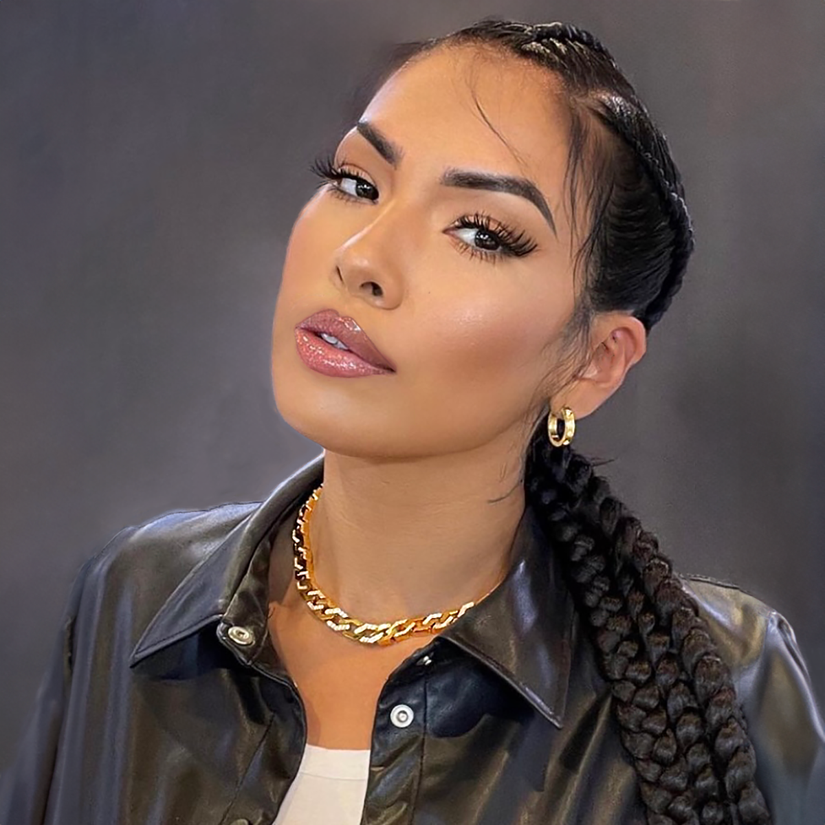 A lady with long braids showing  B.Tiff Blue Pavé 16-Stone Hoop Earrings