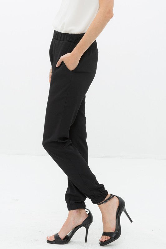 Model showing pocket of Ro &amp; De Ankle Cuffed Black Crepe Pants In Black
