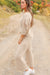 Model standing in the middle of a country dirt road showing side view of Journey Pant- color is ivory